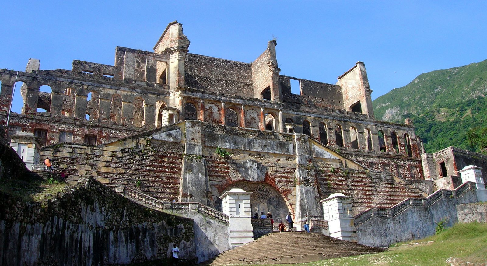 The ruined facade and grand staircase of the Palais Sans-Souci